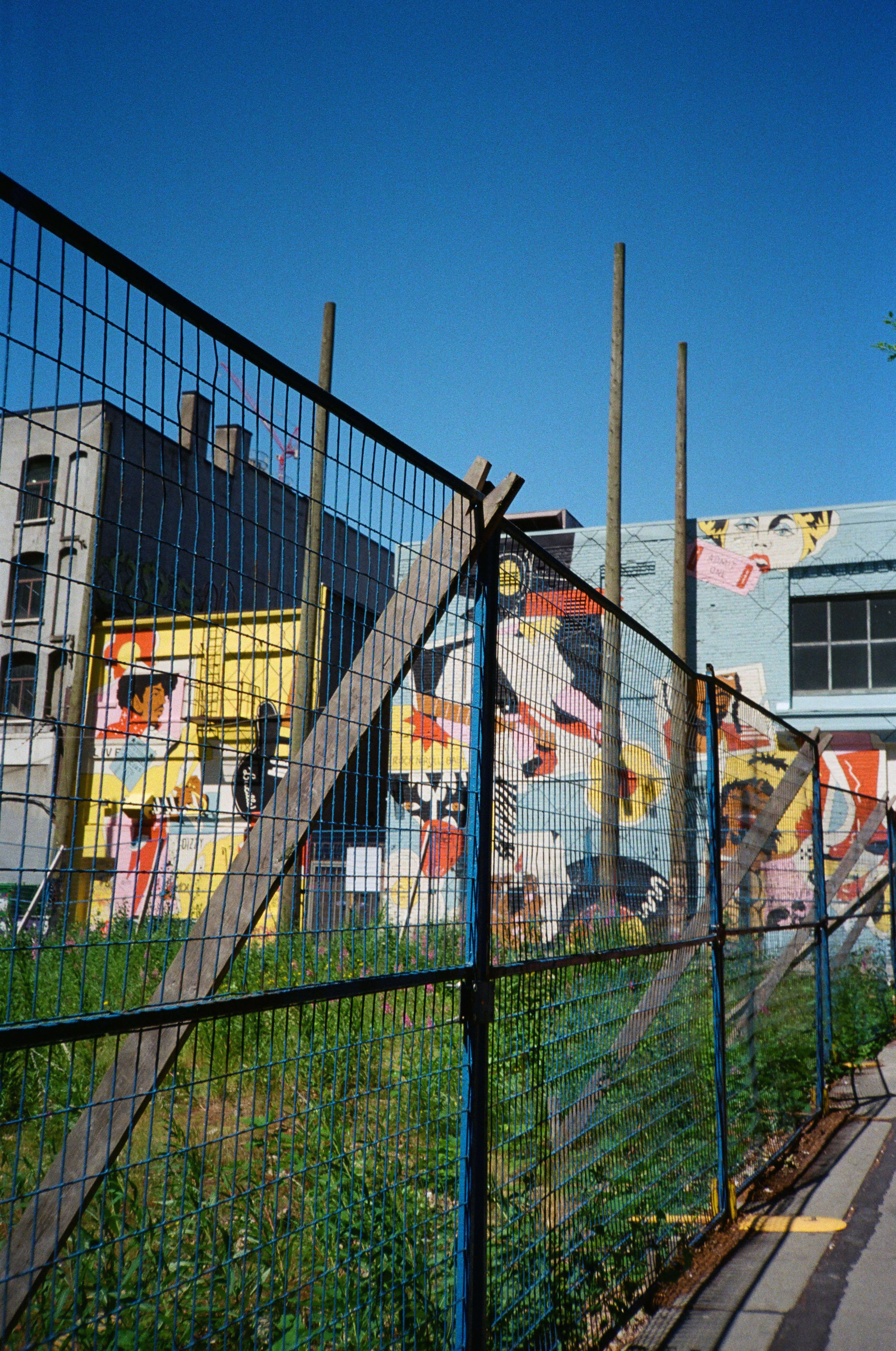 Fence over building murals